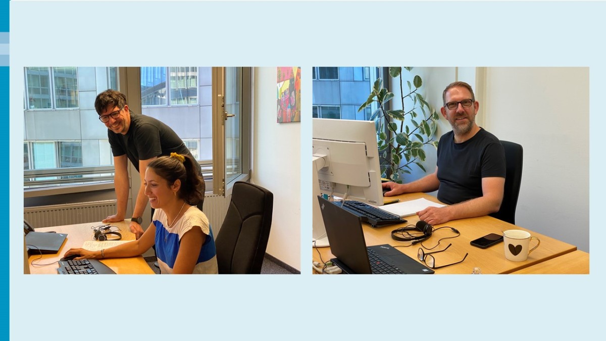 Links: Ein Mann mit dunklem Haar, dunklem T-Shirt und dunkler Brille steht hinter einer Frau mit dunklem Haar und blau-weißem T-Shirt an einem Schreibtisch. Beide lachen. Durch die Fenster im Hintergrund sieht man eine graue Gebäudefront. Rechts: Ein Mann mit Bart und dunklem T-Shirt sitzt an einem Schreibtisch und blickt freundlich in die Kamera. Hinter ihm ein Gummibaum. Auf dem Tisch steht eine weiße Kaffeetasse mit einem schwarzen Herz. Eine Brille, ein Smartphone und ein Headset liegen auch auf dem Tisch.