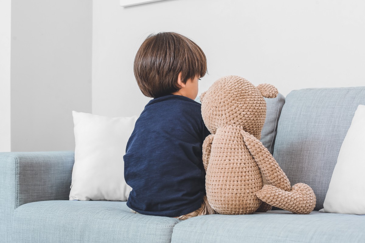 Junge mit Teddy in Rückenansicht