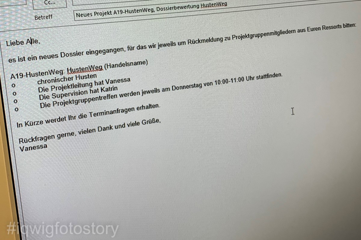 Bildschirm mit einer Mail, in der Vanessa die Ressortleitungen bittet, die Projektgruppenmitglieder für die Bewertung des neuen Wirkstoffs HustenWeg zu benennen. 