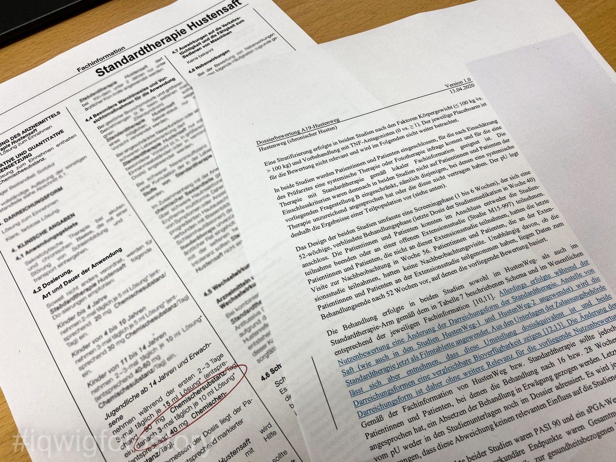 Zwei Ausdrucke auf einem Tisch: die neue Fachinformation und der Abschnitt der Dossierbewertung, in dem es um die Standardtherapie geht. Hier wurde in blauer Schrift eine Zusatzinformation eingefügt.